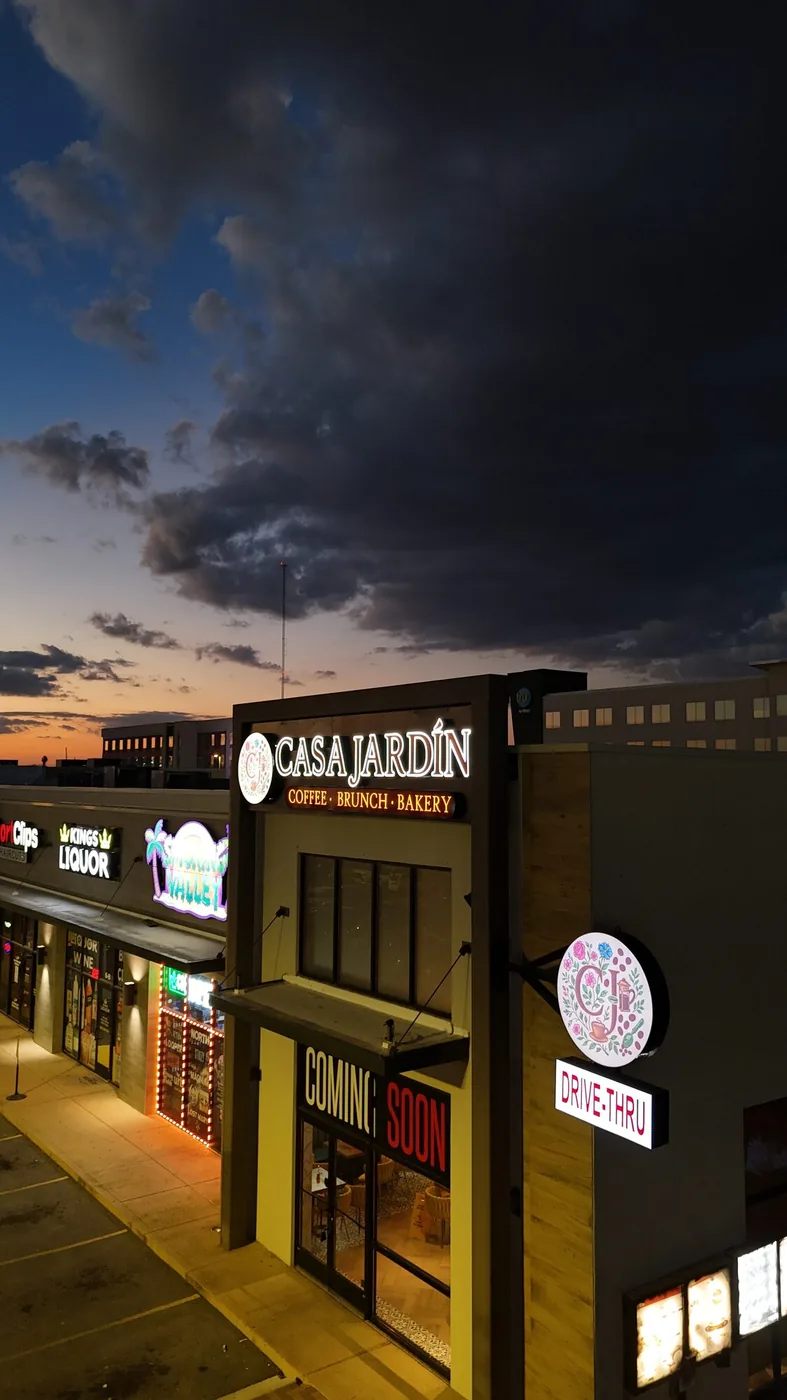 Casa Jardín storefront and its actual illuminated sign at dusk