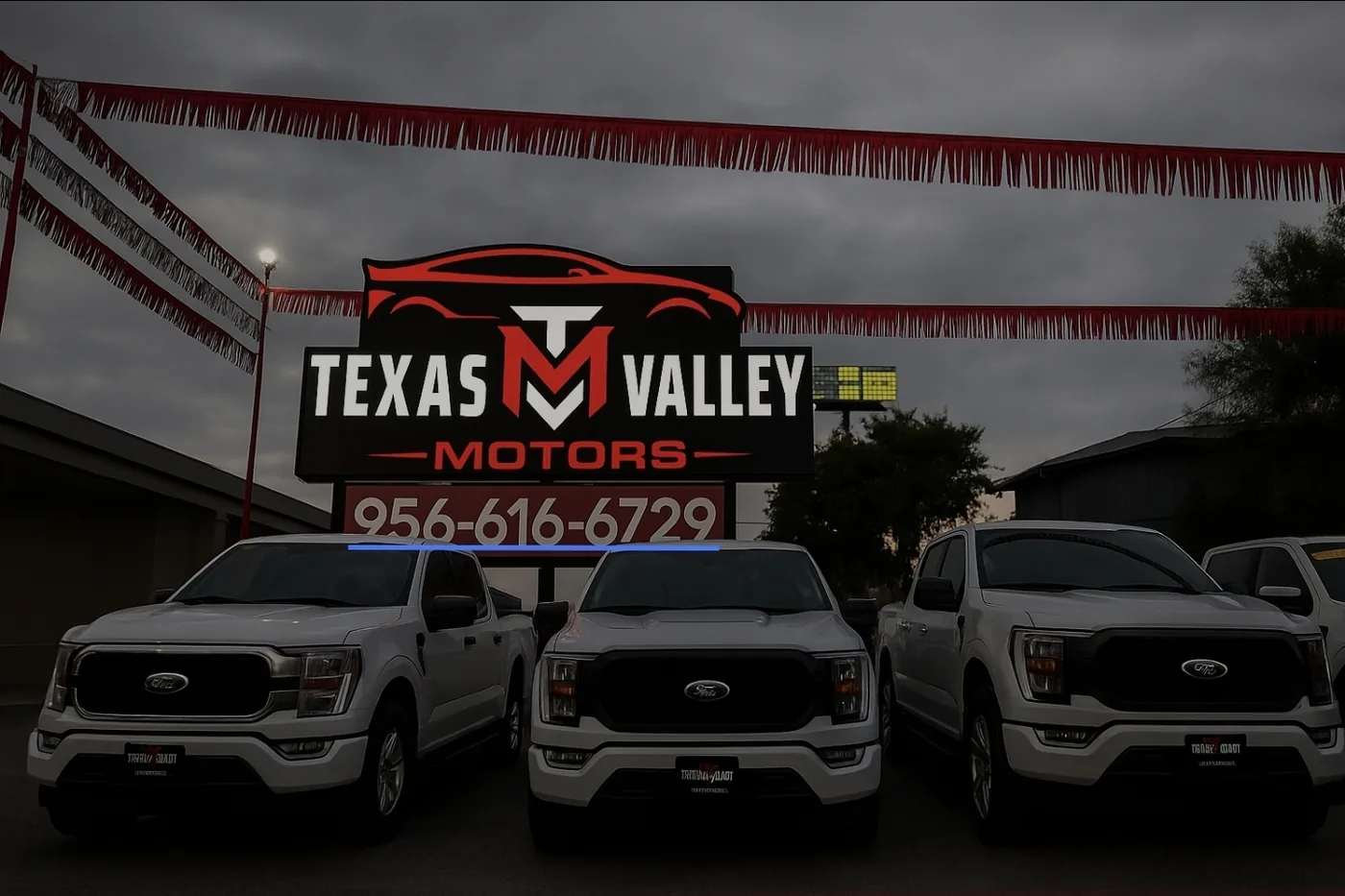 Trucks parked at the actual Texas Valley Motors storefront beneath its original sign